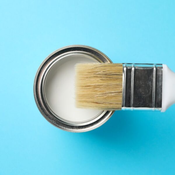 puszka białej farby na niebieskim tle