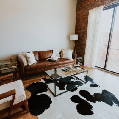 salon loft - kanapa, fotel, dywan, cegły, biel i czerń