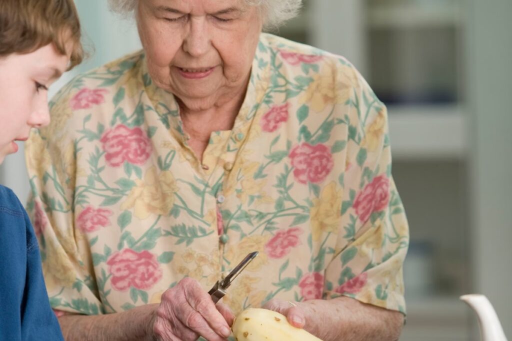 wnuczek pomagający babci w obieraniu ziemniaków na dzień babci