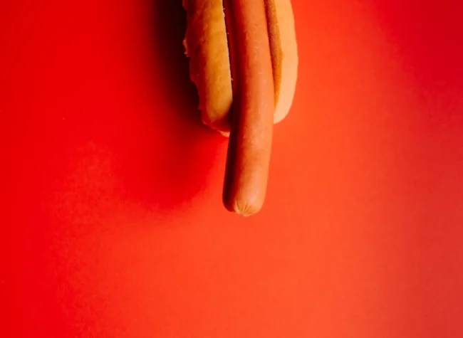 parówka w bułce na pomarańczowym tle