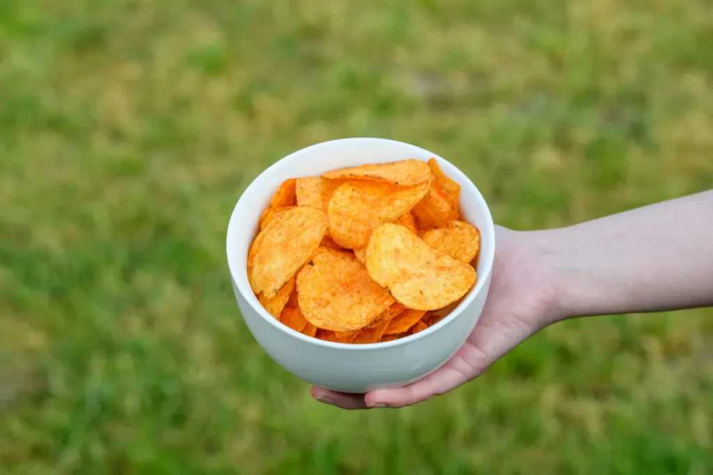 chipsy ziemniaczane w misce trzymane przez człowieka