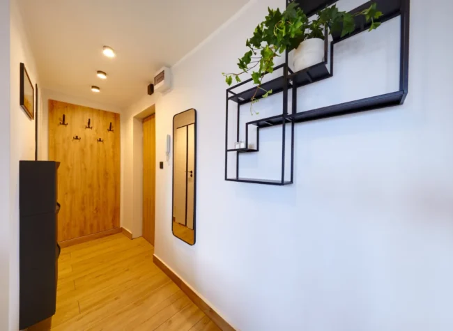 typowy polski przedpokój, ale w nowym mieszkaniu o białego koloru ścianach