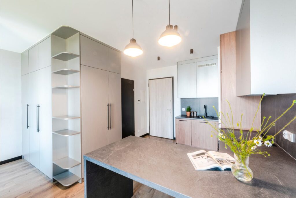 Nowoczesna kuchnia w małym mieszkaniu 30 m z zabudową do sufitu i jasnym blatem