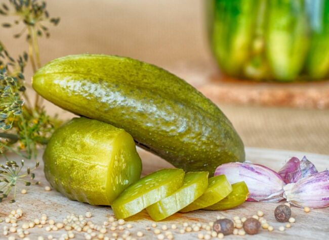Pokrojony ogórek kiszony z przyprawami – kluczowy składnik sałatki na zimę