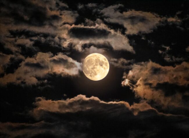 Pełnia księżyca wśród nocnych chmur – dramatyczny krajobraz nieba podczas superpełni.