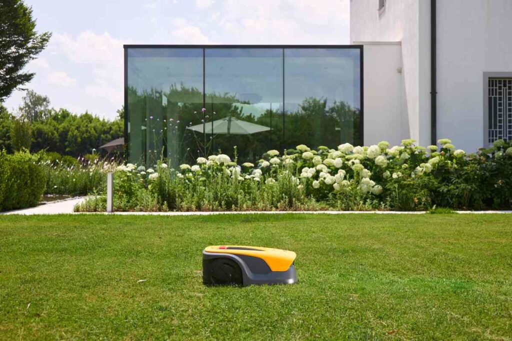 STIGA Vista koszący trawnik przed nowoczesnym domem z dużymi oknami