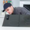 Monter sprawdza płytę indukcyjną przed montażem w kuchni